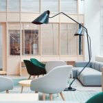 Desain breakout area kantor modern dengan lounge sofa dan aksen kayu