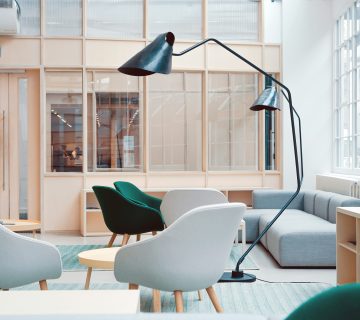 Desain breakout area kantor modern dengan lounge sofa dan aksen kayu