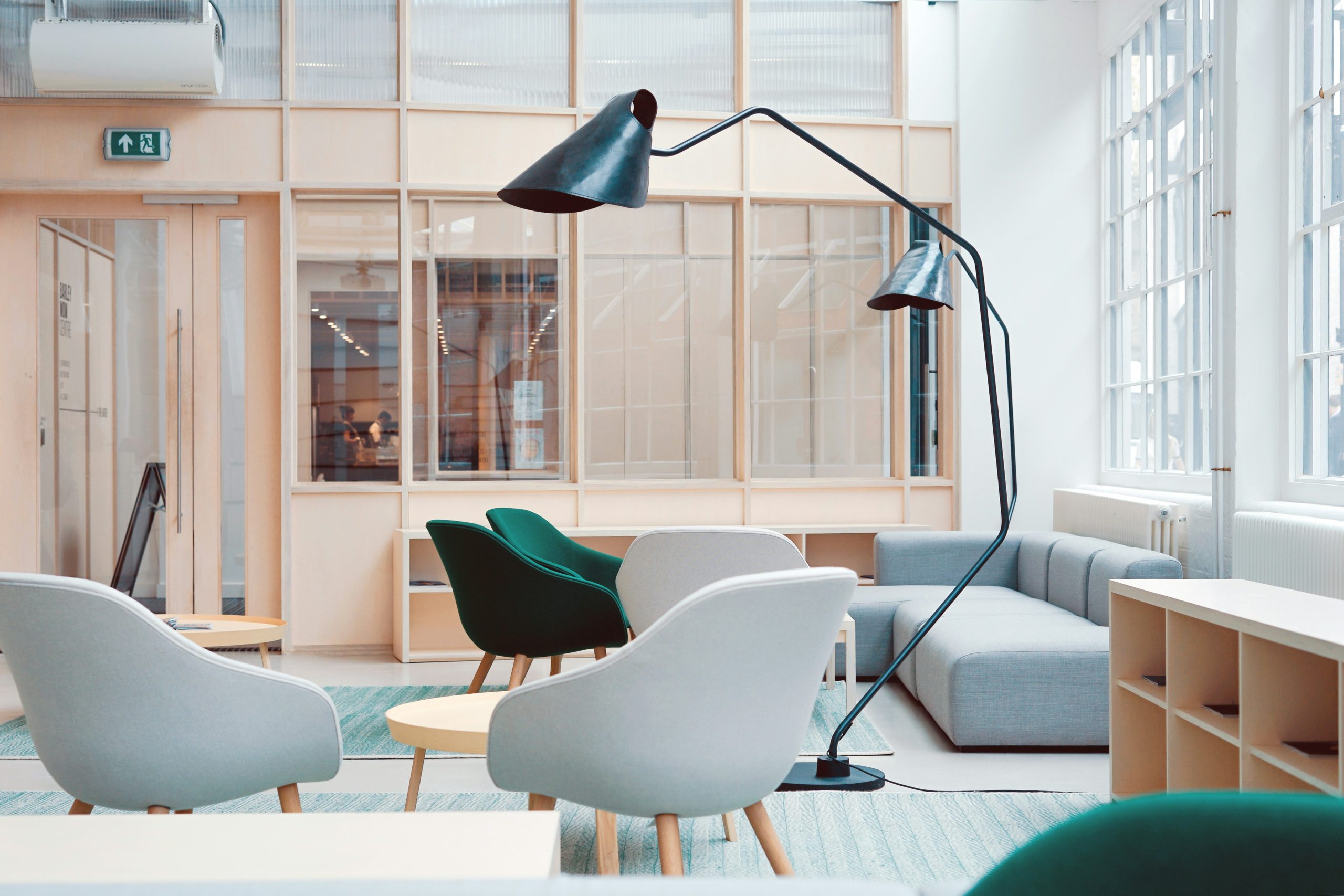 Desain breakout area kantor modern dengan lounge sofa dan aksen kayu